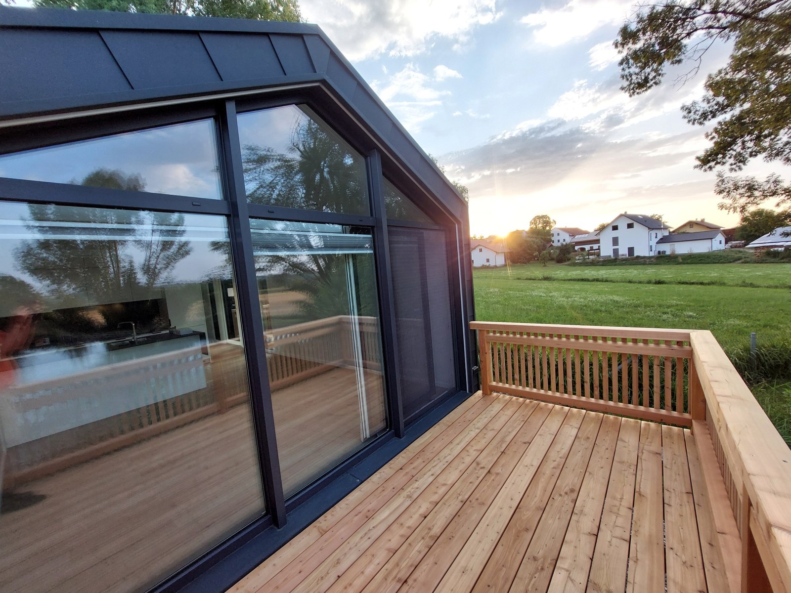 Blick von der Holzterrasse eines Bungalows in Richtung Sonnenuntergang